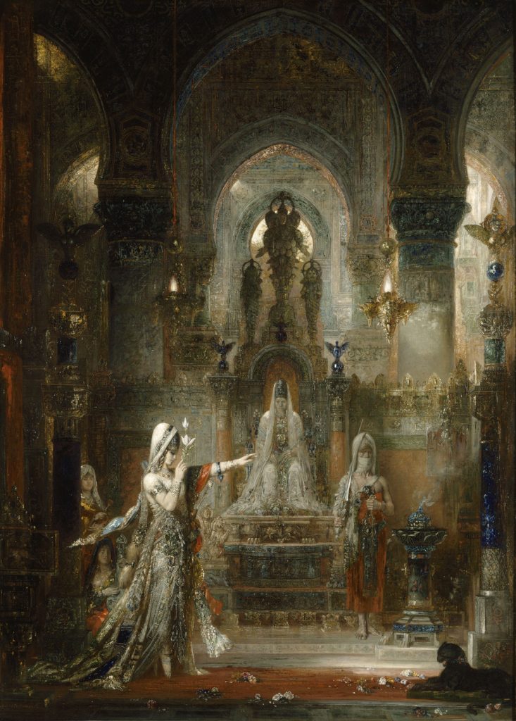 In an ornate palace, filled with gold and riches, a woman in silks clutches a flower and raises her hand in front of an enthroned man surrounded by servants.