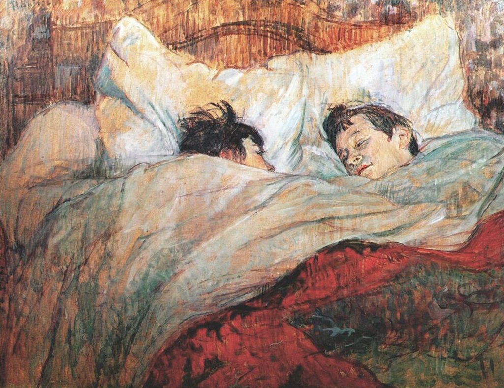 Two faces emerge from the red and white bedsheets of a double bed, looking at each other. Both heads have short brown hair.