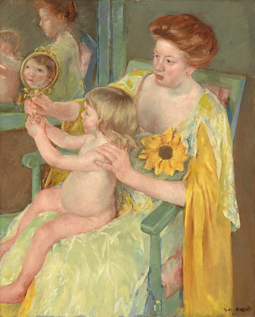 A woman in a yellow dress, her red hair done in a pompadour style, holds a mirror to reflect the naked child in her lap. There is a second mirror on the wall reflecting both figures.