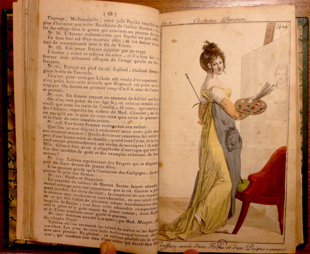 Embedded in this woman's fashion issue is a drawing of a woman, in a yellow dress, standing by a canvas and holding brushes.
