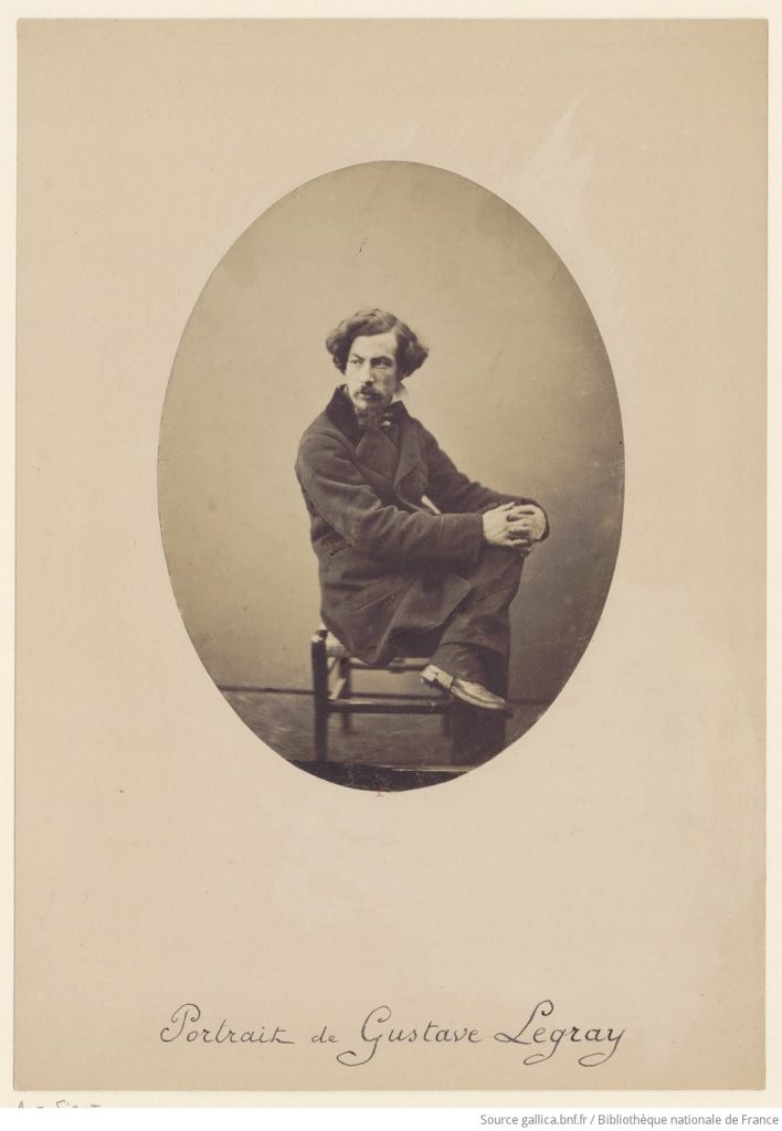 A photographic portrait of a suited man posing to the side, looking out of frame. His hair is carefully done and his name, Gustave Le Gray, is inscribed below.