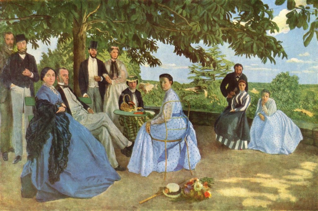 A large group of formally dressed guests pose in a garden, their blue and black clothes contrasting to the vast green.