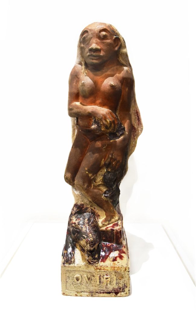 A terracotta female nude, a beast snarling and her foot. 'OVIRI' is inscribed at the piece's pedestal.