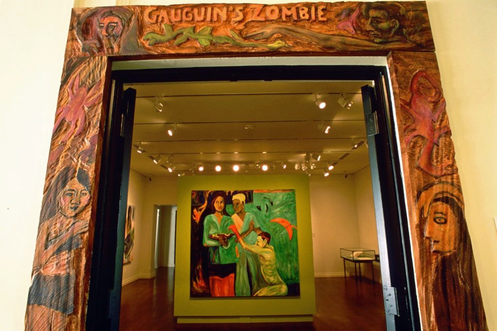 A contemporary photograph of an exhibition stylistically titled as 'Gauguin's Zombie'. Inside, we see a Gauguin work.