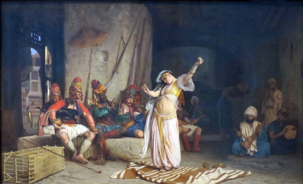 A pale skinned woman dancer is pictured before an orientalized sequence of men of affluence.