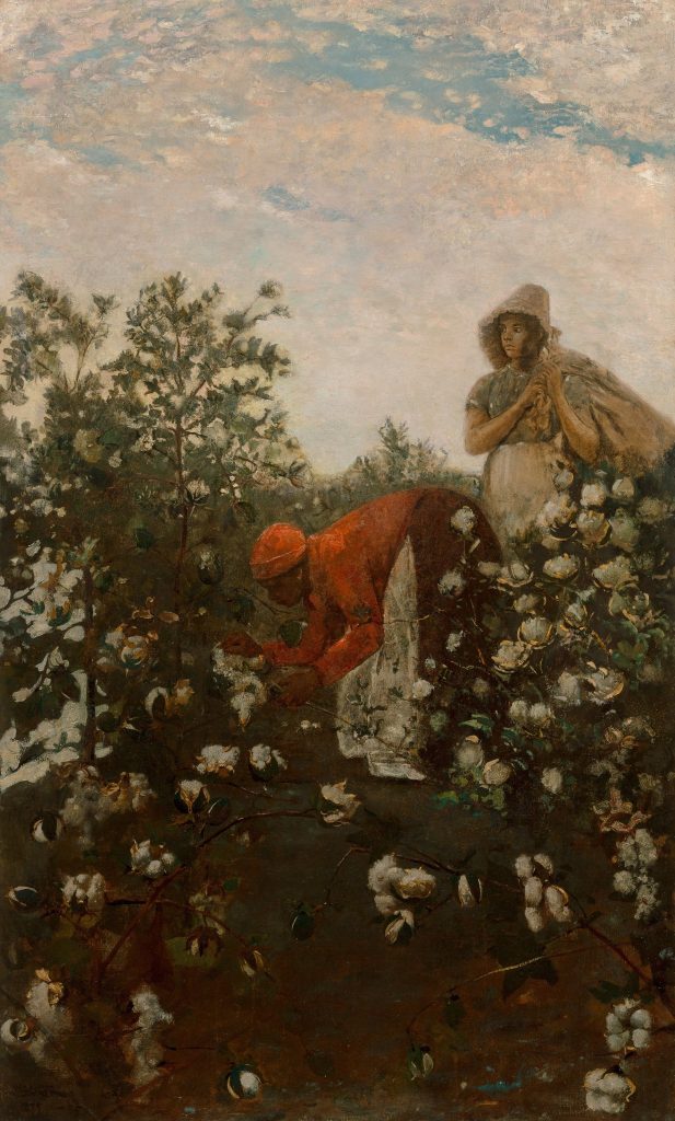 Two black woman in coloured fabrics pick cotton in a field.