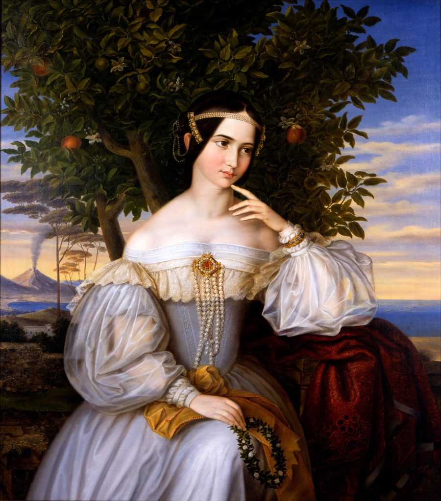 A portrait of a woman in loose opulent garments before an apple tree. Her finger placed to her chin.