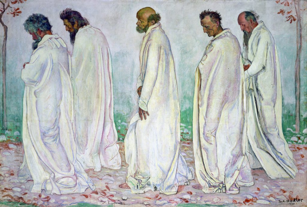 A congregation of aged men in white robes walk from right to left before a pale backdrop.