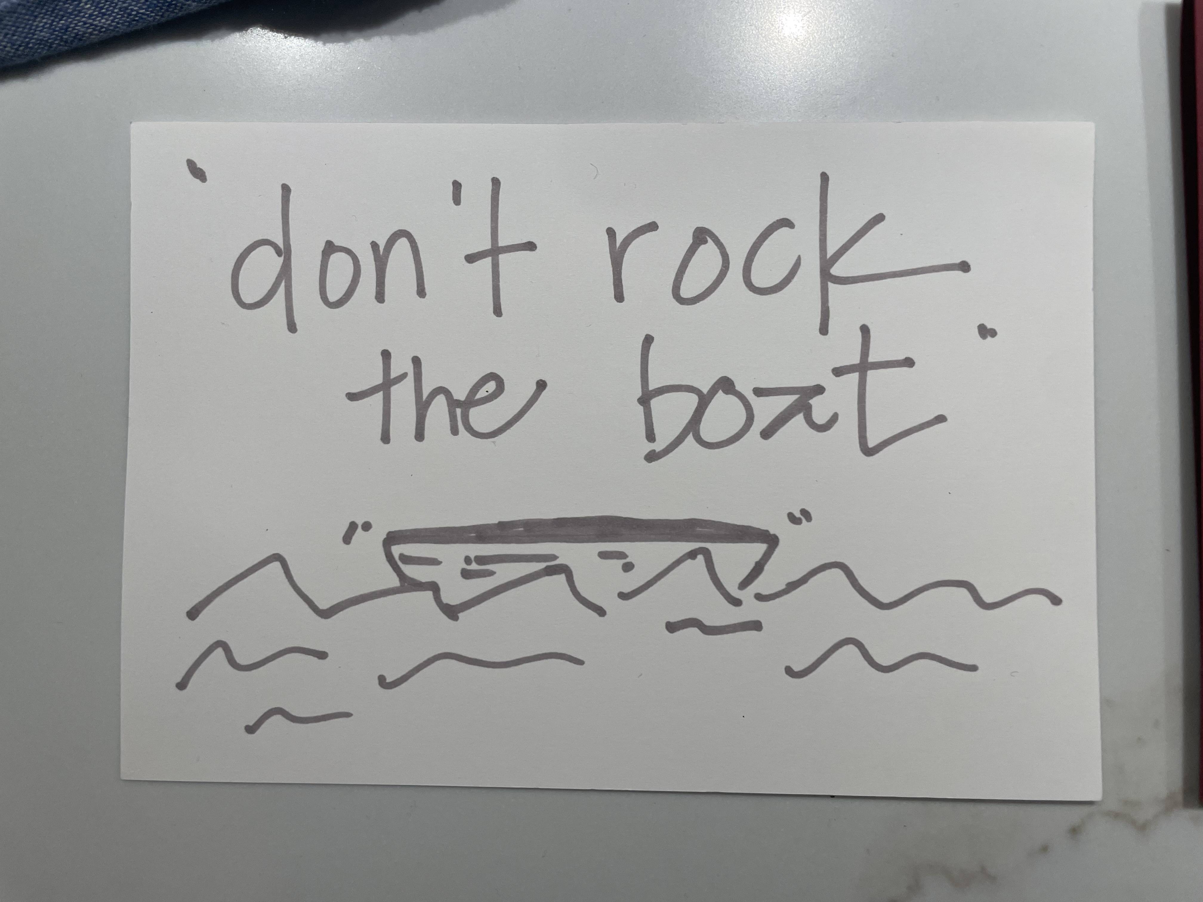 drawing on a sheet of paper that reads 'don't rock the boat' with a boat in water underneath