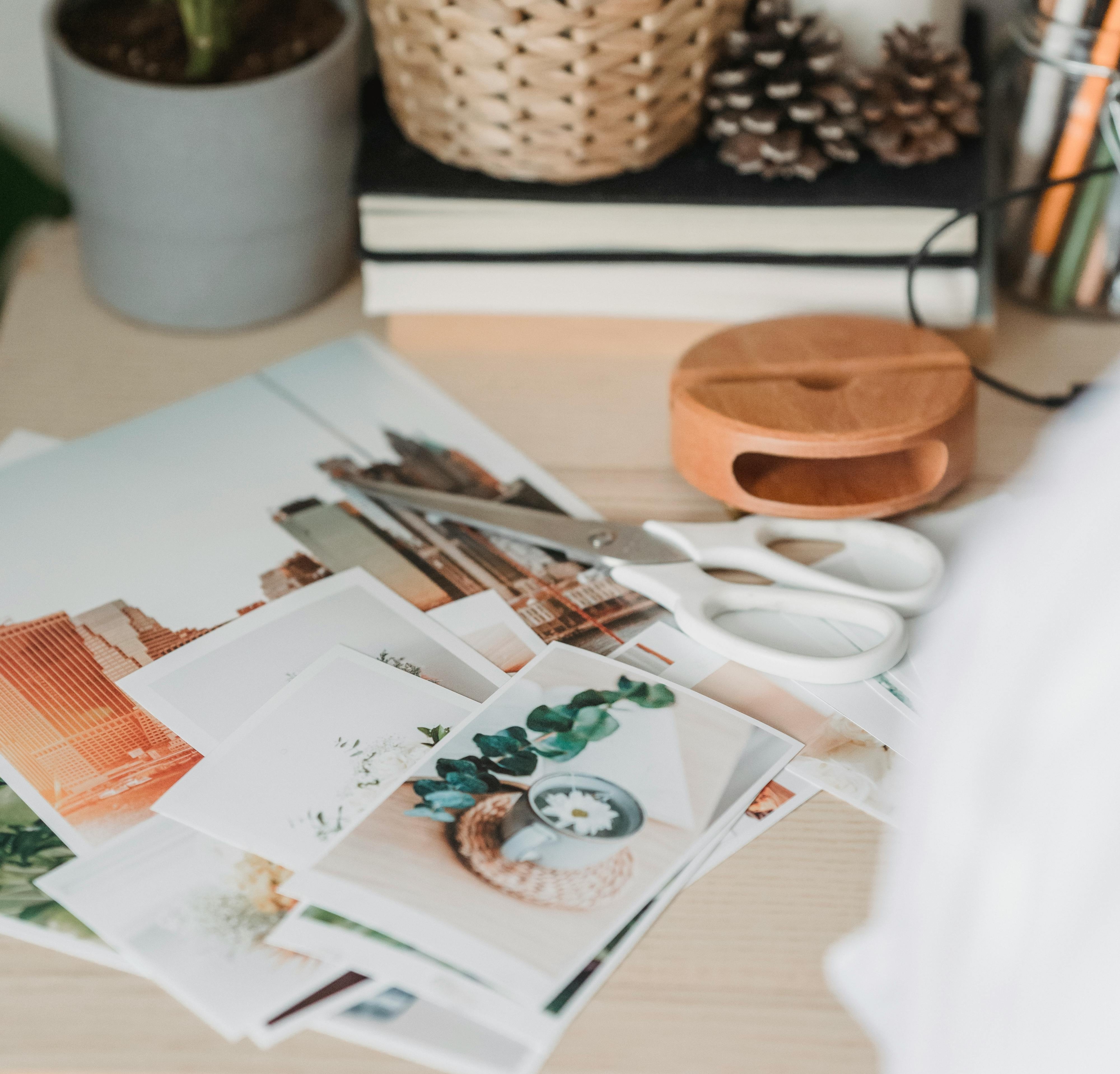 Printed photos on a table with scissors