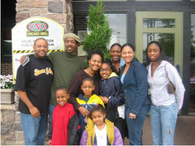 Family of 10 posing together for a photo in front of a restaurant
