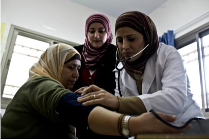Nurse wearing a hijab taking another woman's blood pressure
