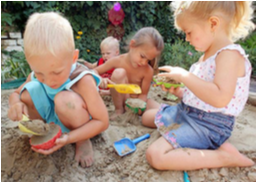 Children playing together with toys in the sand