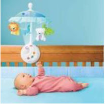 Baby laying on a bed while playing with a crib mobile
