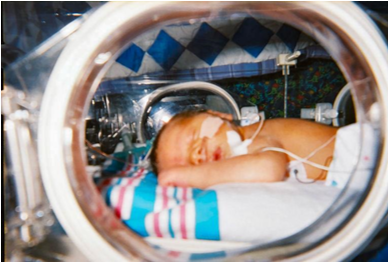 Newborn sleeping on their side in the neonatal unit