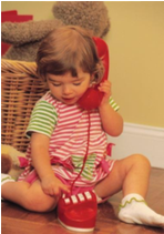 Little girl playing with a toy telephone.