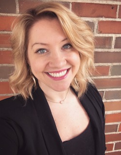 A woman with blond hair smiles at the camera.