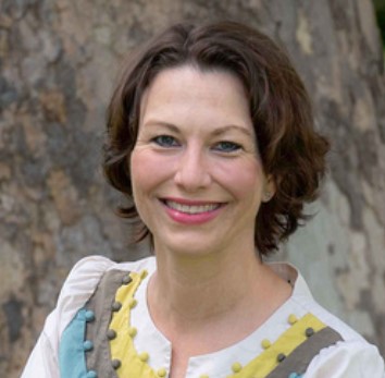 A woman with short brown hair smiles at the camera.