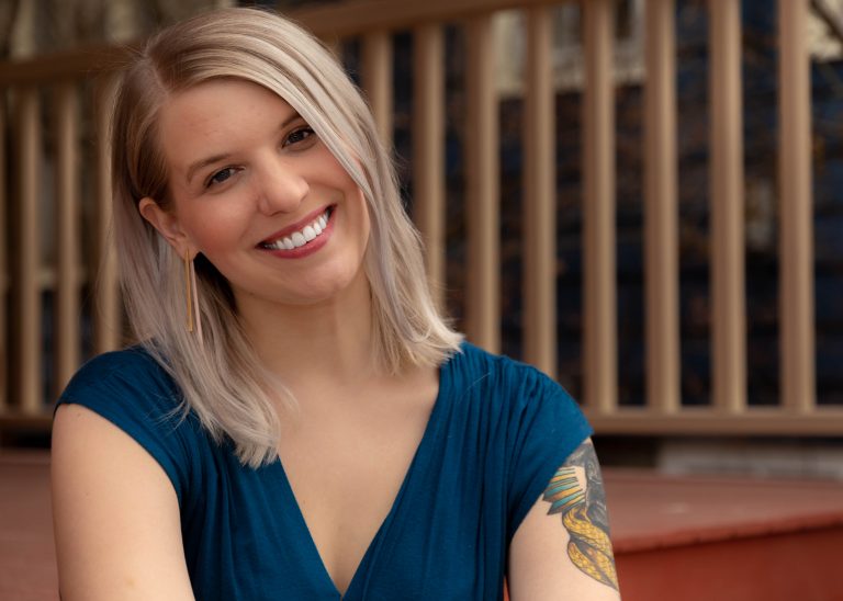 A woman with blond hair smiles.